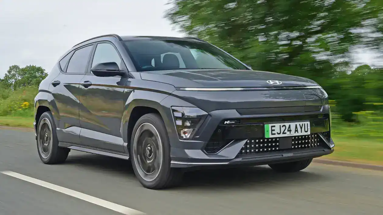 Használt elektromos autó (5) Modern zöld elektromos autó úton közlekedve, amely jó példa arra milyen autó lehet ideális választás ha használt elektromos autót érdemes venni nagy kwh akkumulátorral.A tesla model 3 is kiváló használt autó választás.